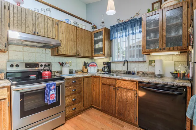 a kitchen with stainless steel appliances granite countertop a sink stove and cabinets