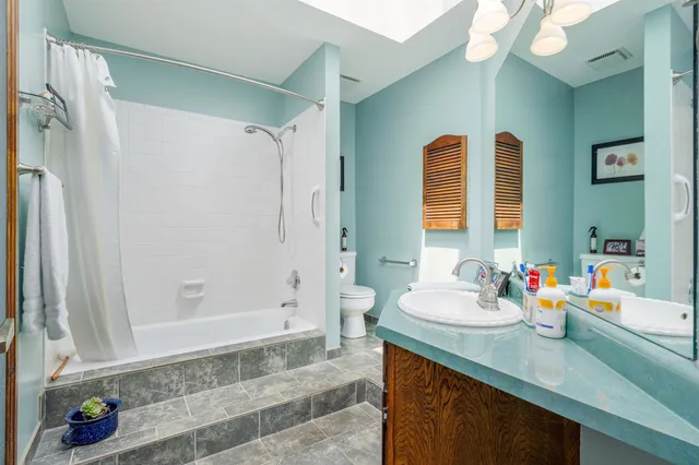 a bathroom with a sink double vanity granite tub shower and a mirror