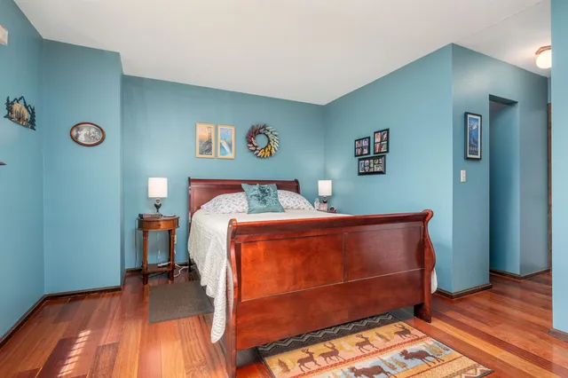 a bedroom with a bed and wooden floor