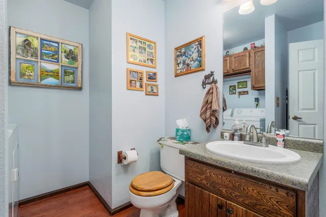 a bathroom with a granite countertop toilet and a sink