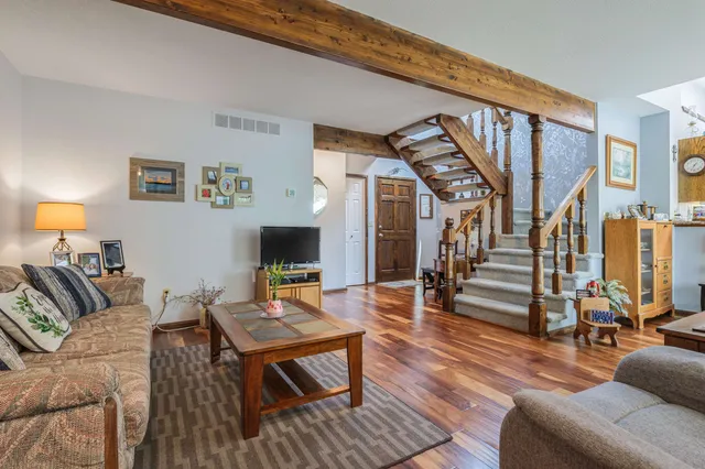 a living room with furniture and a wooden floor