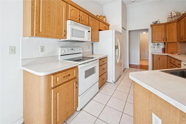 a kitchen with stainless steel appliances kitchen island granite countertop a refrigerator a stove a sink and a microwave