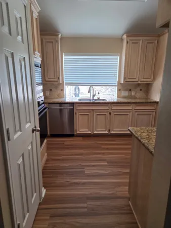 a kitchen with granite countertop a refrigerator and a sink