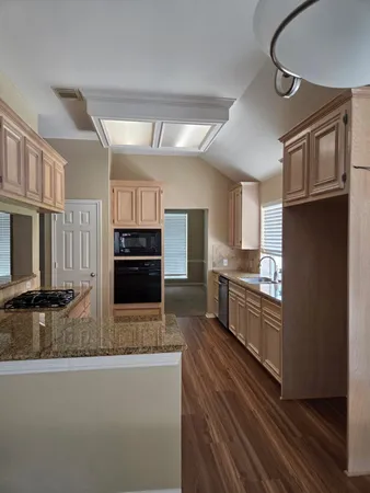 a kitchen with stainless steel appliances granite countertop a refrigerator a stove and a sink