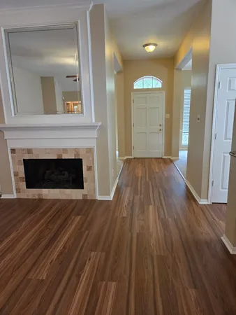 a view of a livingroom with wooden floor and a fireplace