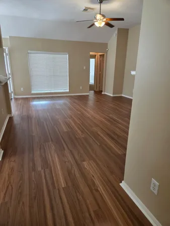 wooden floor in an empty room with a window
