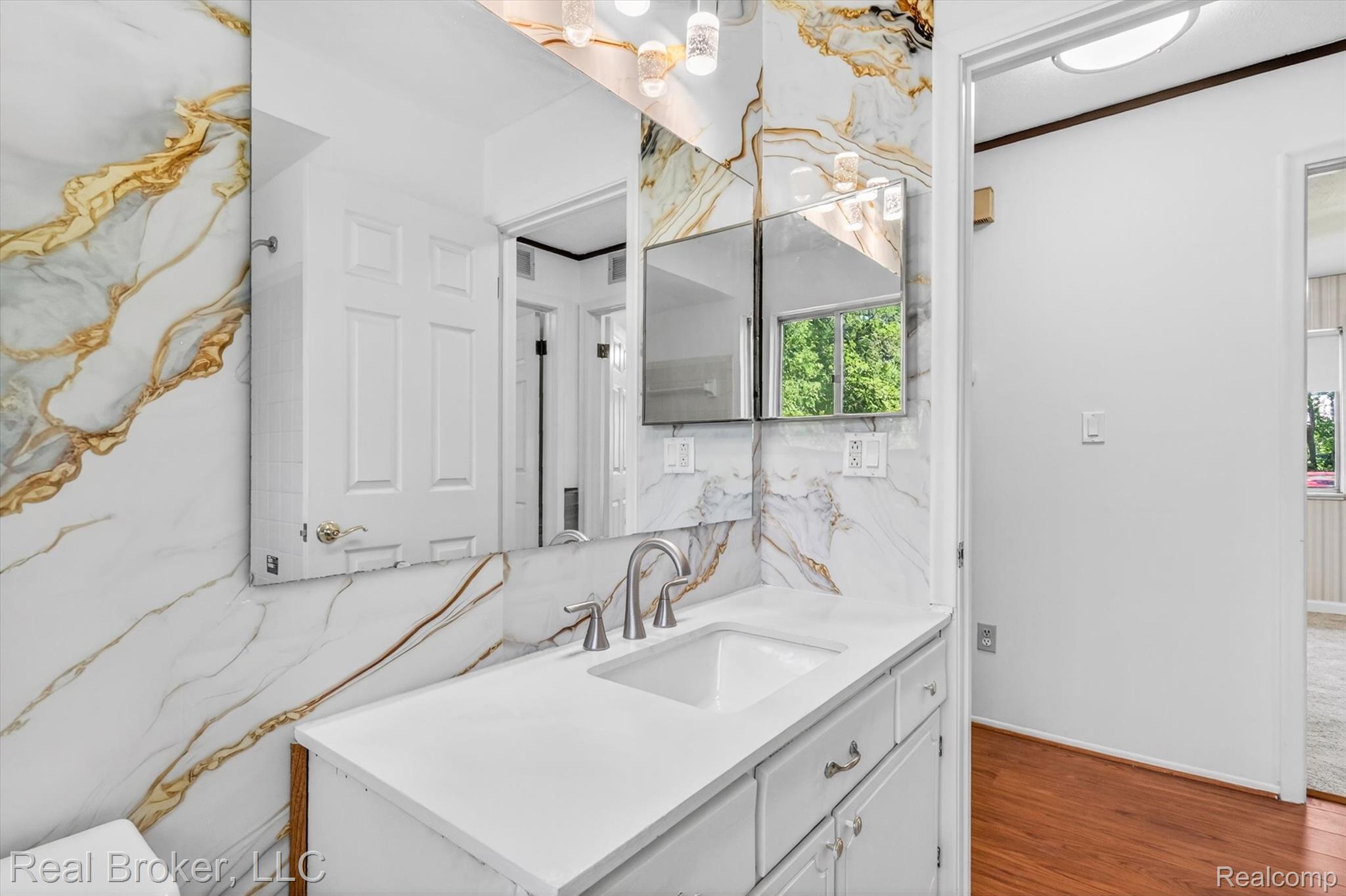 48050 Hull Road Belleville, MI 48111 - Photo 34 of 39 Bathroom vanity featuring a single basin sink, brushed nickel faucet, white countertop, and white cabinetry