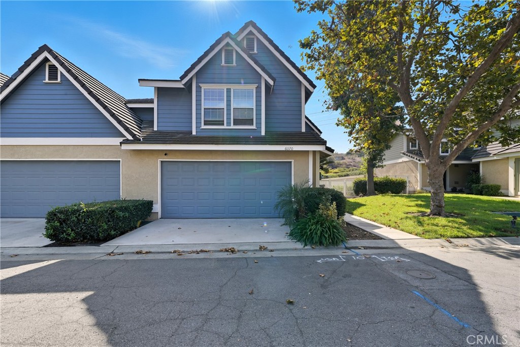 6070 East Summit Court Anaheim Hills, CA 92807 - Photo 12 of 60 a front view of a house with a yard and garage