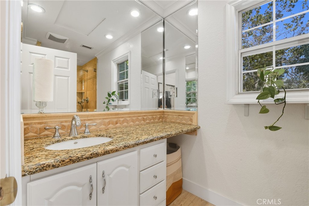 6070 East Summit Court Anaheim Hills, CA 92807 - Photo 41 of 60 a bathroom with a granite countertop sink and a mirror