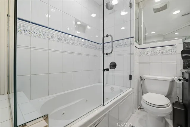 a view of a lake with a bench and trees in the background