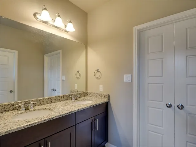 a bathroom with a granite countertop sink and a mirror