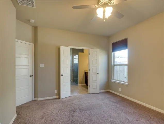 an empty room with windows and closet area