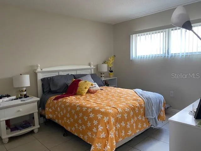 a bed sitting in a bedroom next to a window