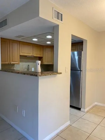 a view of a kitchen with a refrigerator and a sink
