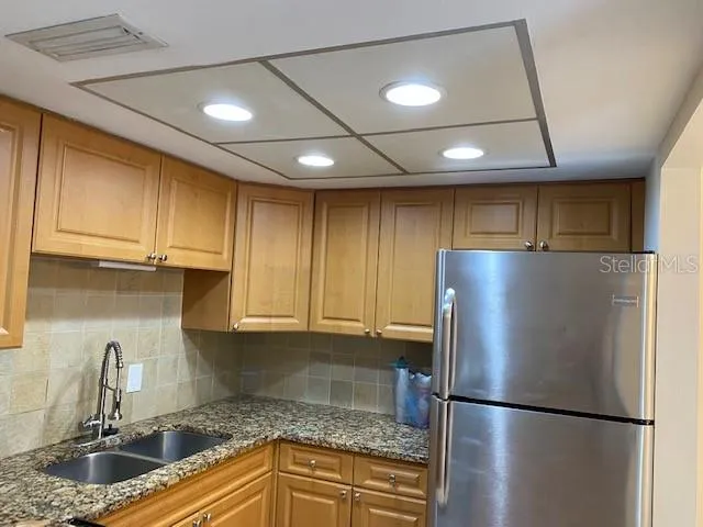 a kitchen with a refrigerator and a sink