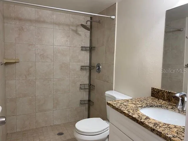 a bathroom with a granite countertop sink toilet and shower