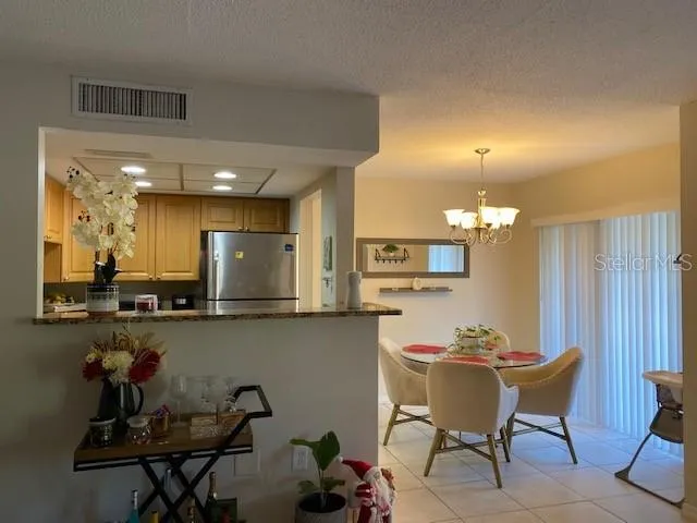 a kitchen with a dining table chairs and a refrigerator