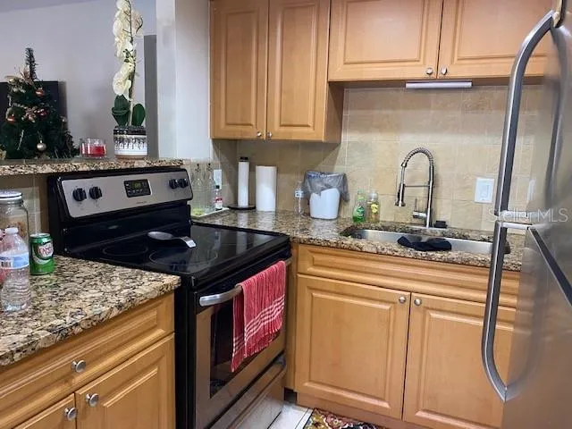 a kitchen with stainless steel appliances granite countertop a stove and a sink