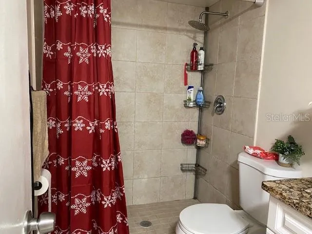 a bathroom with a toilet sink and shower curtain