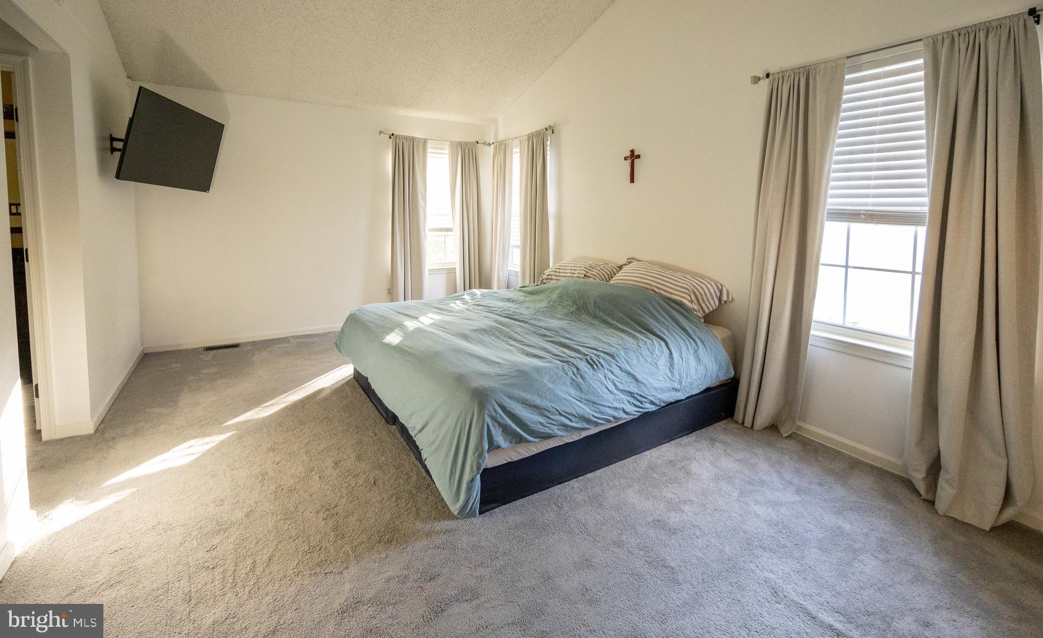 15 Timber Court Glassboro, NJ 08028 - Photo 17 of 32 a bedroom with a bed a flat screen tv and windows