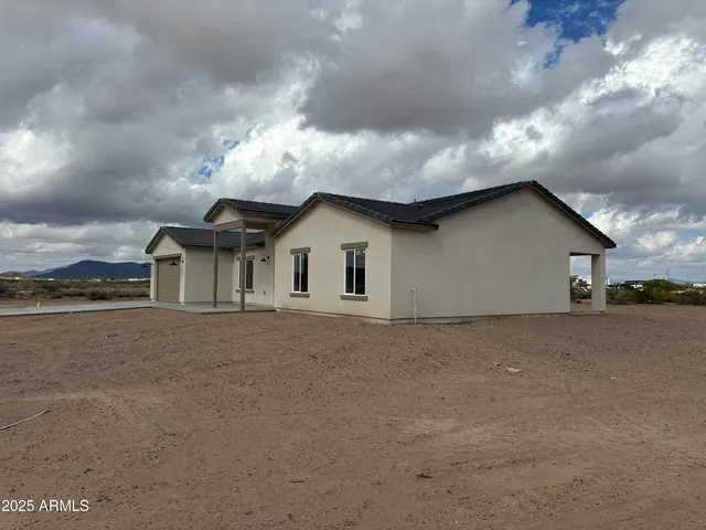 a view of a house with roof and wooden fence