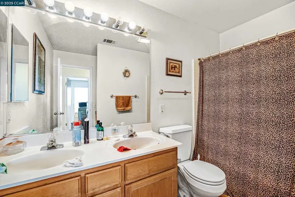 a bathroom with a sink vanity mirror and toilet