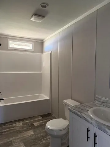 a bathroom with a granite countertop toilet a sink and bathtub