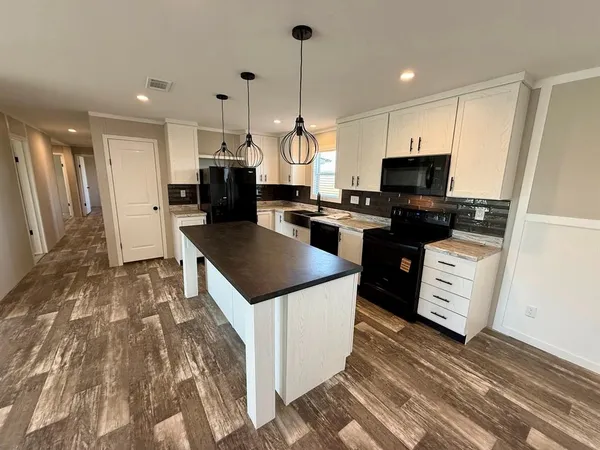 a kitchen with a sink a counter top space stainless steel appliances and a window