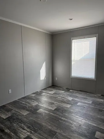a view of an empty room with window and closet area