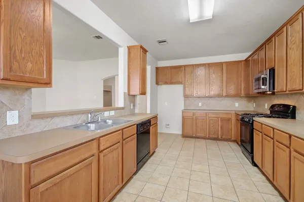 a kitchen with a sink stove and cabinets
