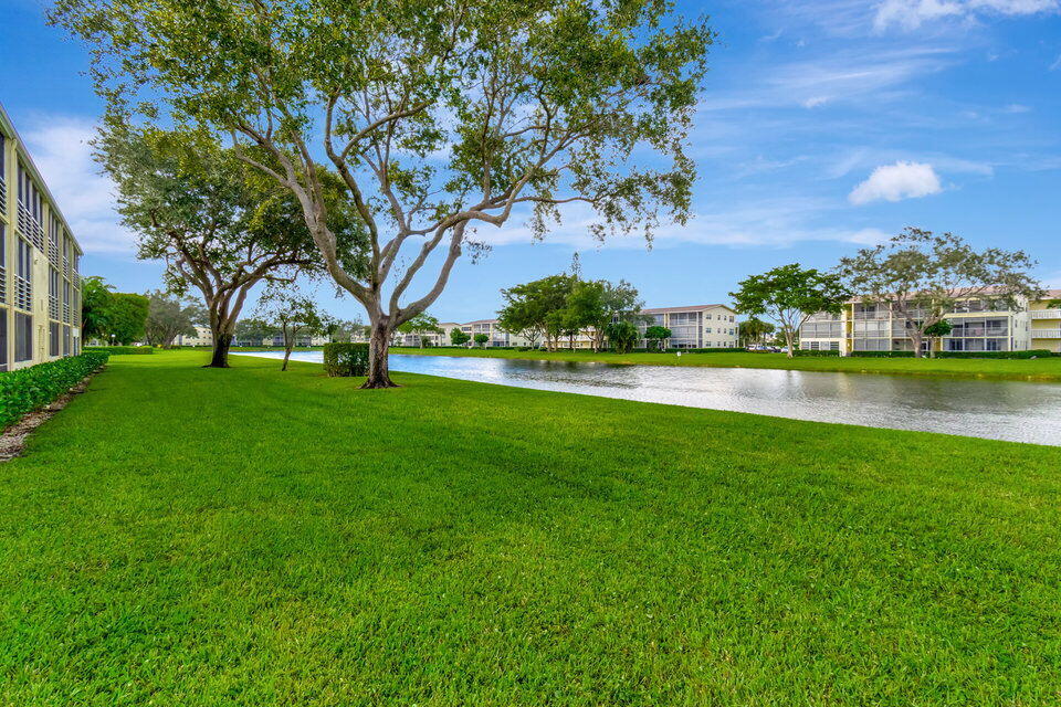 150 Dorset D, Unit 150 Boca Raton, FL 33434 - Photo 36 of 82 a view of a garden with a building in the background