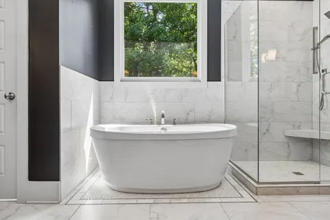 a white bath tub sitting next to a shower