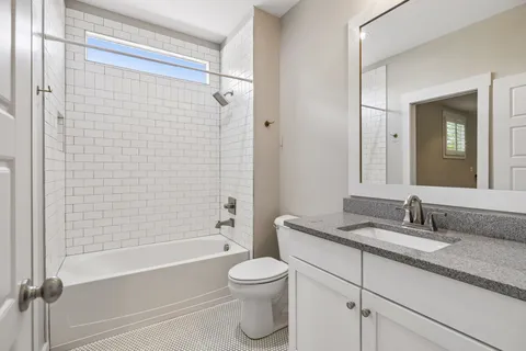 a bathroom with a granite countertop toilet a sink and a bathtub