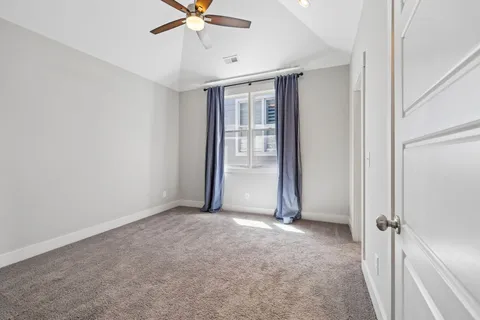 an empty room with closet and a ceiling fan