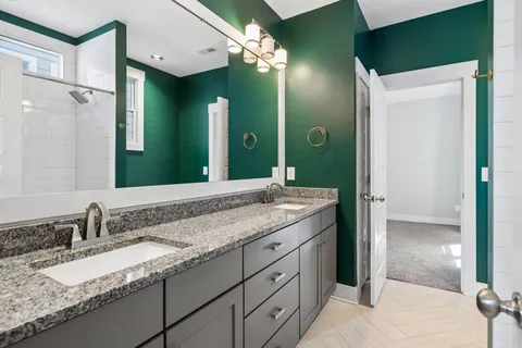 a bathroom with a granite countertop sink and a mirror