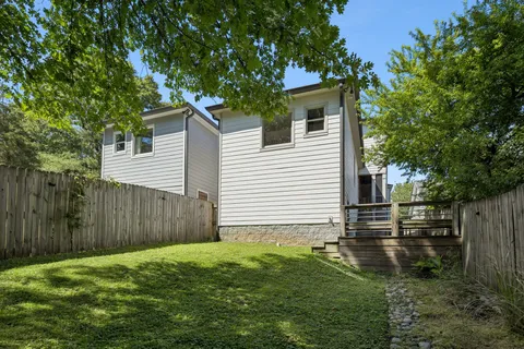 a backyard of a house with plants and tree