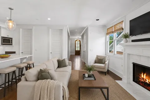 a living room with furniture a flat screen tv and a fireplace