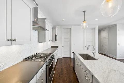 a kitchen with stainless steel appliances granite countertop a sink stove and refrigerator