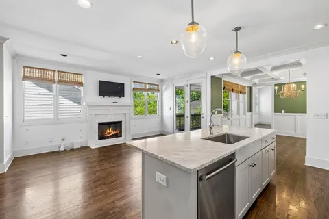 a kitchen with a stove center island a sink and a fireplace