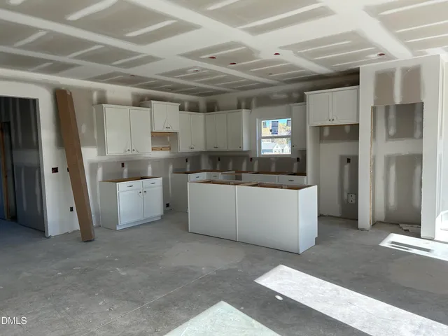 a living room with stainless steel appliances kitchen island granite countertop furniture and a refrigerator