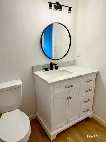 a bathroom with a sink mirror vanity and toilet