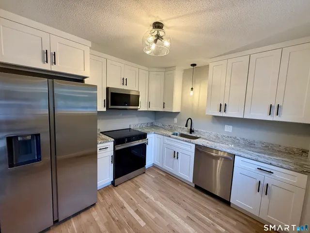 a large kitchen with cabinets stainless steel appliances and a counter space
