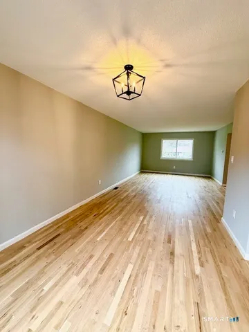 a view of a room with wooden floor and ceiling fan