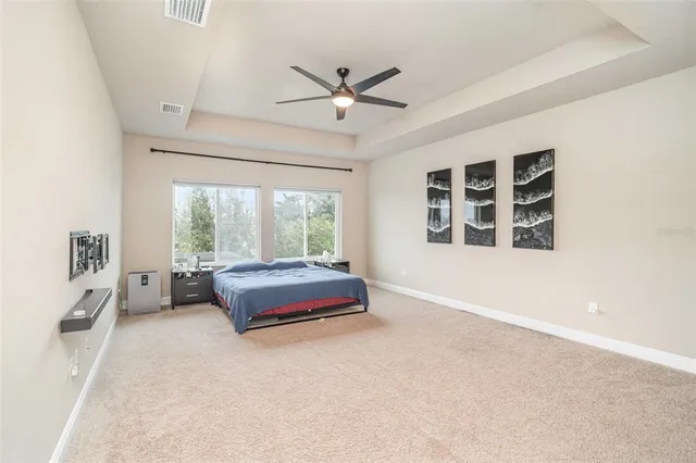 a view of a livingroom with a chandelier fan and wooden floor