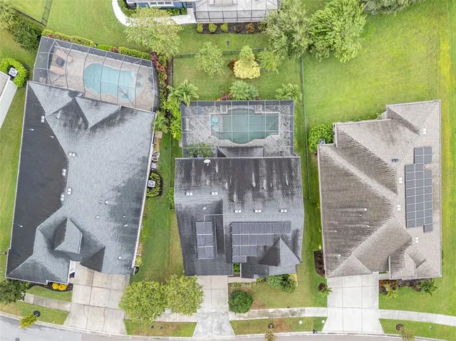 an aerial view of residential houses with outdoor space and trees