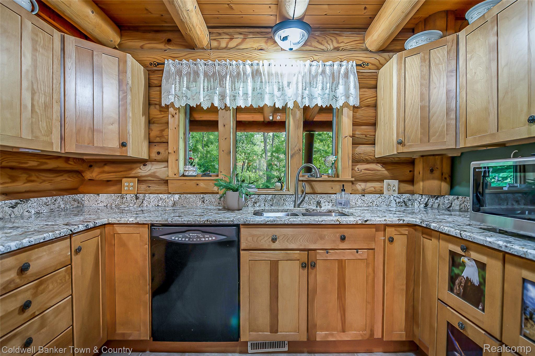 7023 Munsell Road Howell, MI 48843 - Photo 27 of 55 U-shaped kitchen with wood cabinetry, light-toned countertops, and a stainless steel sink