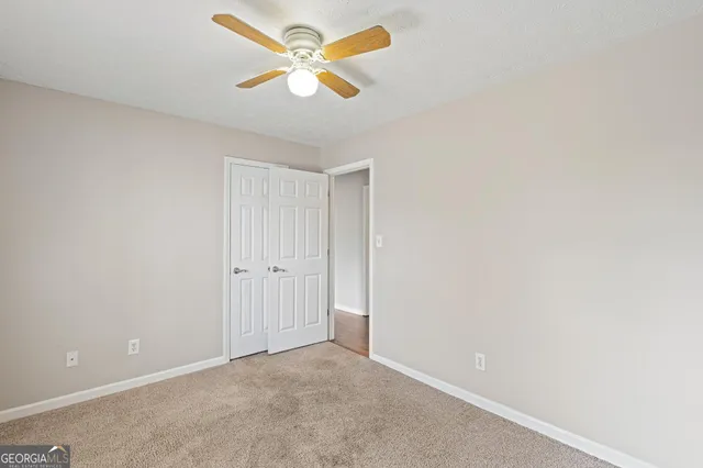 an empty room with a window and a ceiling fan