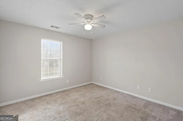 a view of an empty room with a ceiling fan