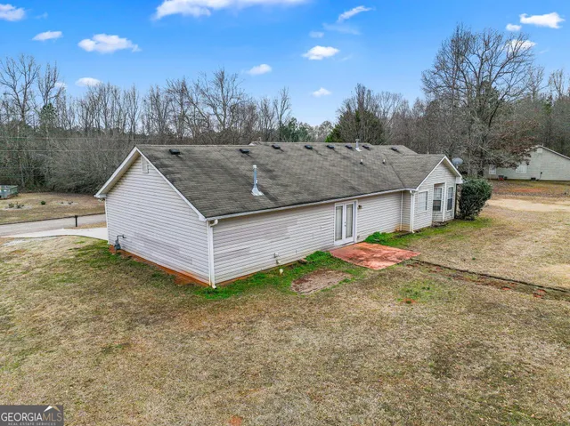 a view of a house with backyard and trees