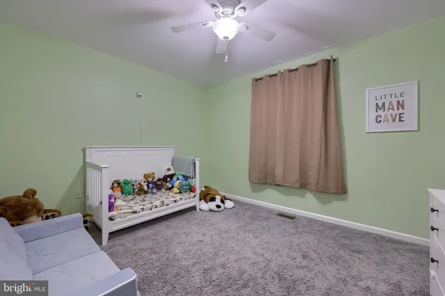 a living room with furniture and a baby crib